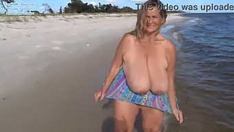 Watch A Busty Woman Show Off Her Curves In A Swimsuit On The Beach